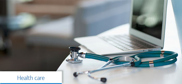A stethoscope and a laptop computer. Text reads, “Health care.”