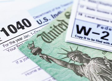 Article Image - Image of lincome tax documents and a return check. Read how you can plan to lower your 2022 tax bill.