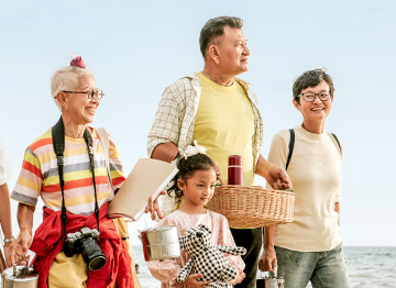 Article Image - 3 generations of family walking along the beach. Plan a family vacation without breaking the bank