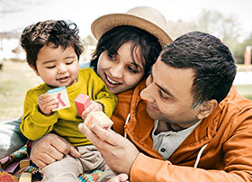 Article Image - Parents holding a toddler. Learn how to find the best healthcare coverage for your family.