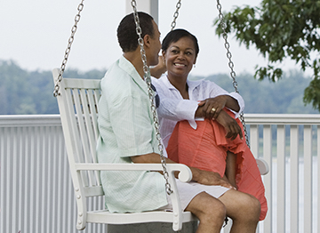 Article Image - A couple sitting on a porch swing. Learn how your home could help fund your retirement.