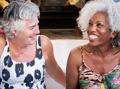 Article Image - Two older women laughing in conversation.